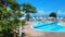 Kemer, Turkey - 09 23 2015: Crystal Aura hotel. Swimming pool with sun loungers and umbrellas, behind sea with yacht and palms