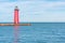 Kenosha, WI/USA - 01-01-2020:  Red lighthouse reflecting in Lake Michigan on a sunny winter day