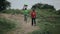 KENYA, KISUMU - MAY 20, 2017: African woman walking through the country road, carrying bowls on her head. Man go near