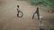 KENYA, KISUMU - MAY 20, 2017: Two african boys playing with tires on the road. Kids having fun together