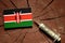 Kenyan flag on a stump with syringe injecting money