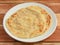 Kerala Paratha, a layered flat bread using wheat flour, popular dish in south India. isolated over a rustic wooden background,