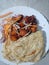 Kerala special porota and chicken fry with carrot onion slices on white plate