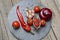 Ketchup chili in a glass gravy boat and its ingredients on a bla