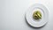 keto bread with avocado, elegantly served on a white plate atop a pristine table against a white wall backdrop