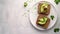 keto bread with avocado, elegantly served on a white plate atop a pristine table against a white wall backdrop