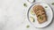 keto bread with avocado, elegantly served on a white plate atop a pristine table against a white wall backdrop