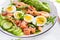 Ketogenic diet breakfast. Salt salmon salad with boiled shrimps, prawns, tomatoes, spinach, eggs and avocado.