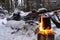 kettle is heated on fire. Finnish candle on the background of snowmobile. concept of relaxing in the forest in winter