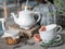 Kettle, jam, old book and wo tea cups with rosemary and grapefruit on the background of a large pumpkin and heather.