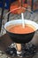 Kettle with vegetable soup hanging over camp fire