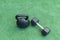 A Kettlebell and a hexagonal dumbbell side by side on synthetic grass