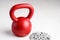 Kettlebell winter fitness, red kettlebell on a white background with silver sparkles and a silver snowflake