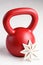 Kettlebell winter fitness, red kettlebell on a white background with silver sparkles and a white snowflake