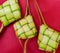 Ketupat Pouches on a red background. Ketupat is a type of dumpling made from rice packed inside a diamond-shaped container of