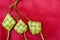 Ketupat Pouches on a red background. Ketupat is a type of dumpling made from rice packed inside a diamond-shaped container of