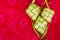 Ketupat Pouches on a red patterned background.