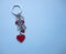 Key chain with red hearts and white letters LOVE on a blue background with copy space top view