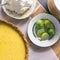 Key lime pie with graham cracker crust. Shown with key limes, whipped cream and a stack of dessert plates.