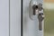 The key in the mortise lock of a white plastic door. Keyhole opening. The concept of forgetfulness and distraction of the landlord