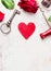 Key, red heart, rose and chocolate on white wooden table, love background