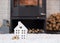 Key to house with keychain against background of fireplace stove with fire and firewood. Cozy home hearth. Building, design,