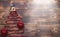 Key to the house with a keychain on top of Christmas tree made of red square beads. Flat lay on wooden background. Building or