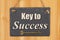 Key to success type message on a hanging chalkboard sign with skeleton key