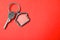Key with trinket in shape of house on red background. Real estate agent services