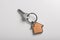 Key with trinket in shape of house on white background, top view. Real estate agent services
