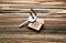 Key with trinket in shape of house on wooden background. Mortgage concept
