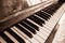 The keyboard of a upright piano in sepia.