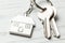 Keychain house and keys on white wooden background