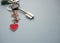 Keychain with red hearts and white letters LOVE in a bunch of keys on a blue background with copy space