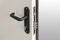 Keyhole and bolts at brown white door with black handle