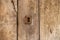 Keyhole and old metal escutcheon on a distressed grungy wooden door, close up texture view