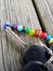 Keys with rainbow beads all over them sitting on a picnic table on a porch