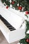 Keys on white upright piano with christmas decor