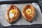 Khachapuri in Adjarian with suluguni cheese and egg, open pies in the form of a boat, baked on a baking sheet