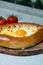 Khachapuri with egg on a wooden tray with wine and tomatoes