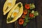 Khachapuri with fresh vegetables caucasian kitchen, close-up on a black wooden table. Adzharian khachapuri. View from above