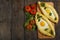 Khachapuri with fresh vegetables caucasian kitchen, close-up on a black wooden table. Adzharian khachapuri. View from above
