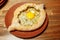 Khachapuri Made From a Delicious Tender Dough with Spinach, Melted Cheese and Butter Close Up. Traditional Hachapuri