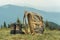 Khaki color boots and backpack standing on a grass on top of a mountain hill