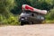 A khaki minibus carry an inflatable rubber rafting boat on the trunk.