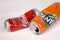 KHARKOV, UKRAINE - DECEMBER 8, 2020: Crumpled aluminium cans of Coca Cola and Fanta soft drinks on white wooden table. Two damaged