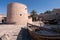 Khasab, Oman - 04.01.2018: Courtyard of medieval arabian fort in Khasab, Oman. Wooden ships exhibition.