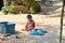 Khmer little boy tired of playing crumpled cans of drinks under