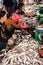 Khmer woman cleaning and selling fish at food marketplace