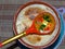 Khokhloma spoon lies on a clay pot with barley porridge from the oven. Barley porridge with milk, butter. Closeup.